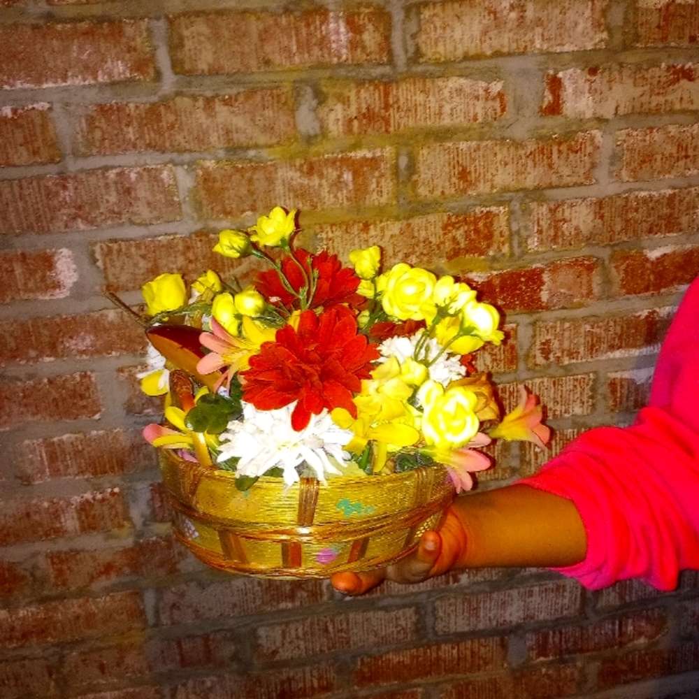 Oval bamboo ribbon basket holding yellow roses,burnt orange and cream flowers.